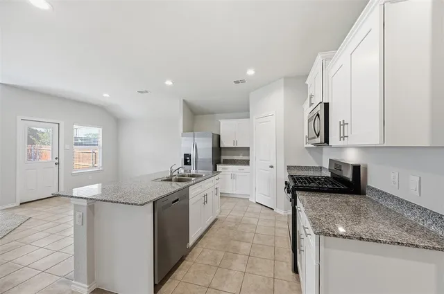 a kitchen with stainless steel appliances granite countertop a sink stove and cabinets