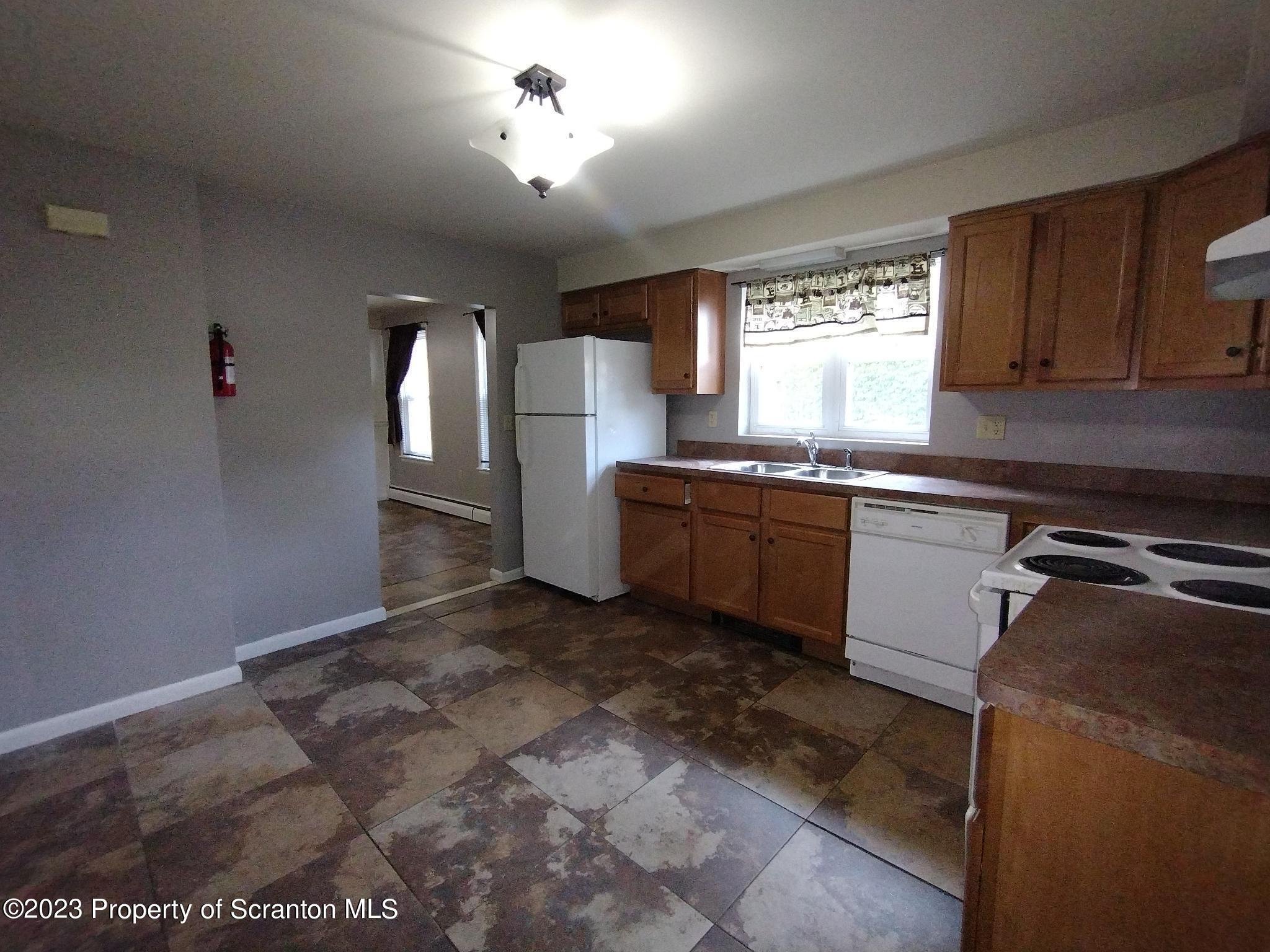 1011 Scranton Street Scranton, PA 18504 - Photo 3 of 6 a kitchen with stainless steel appliances granite countertop a sink a stove a refrigerator cabinets and a window