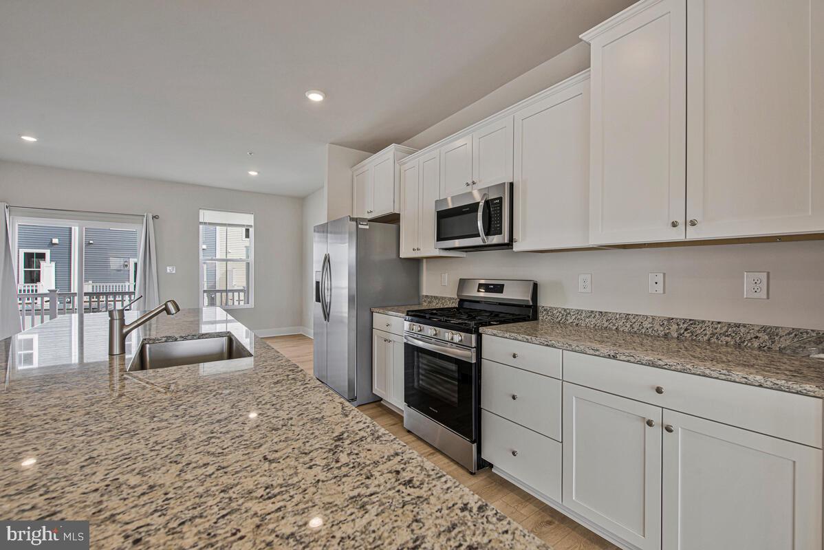 7268 Contee Road Laurel, MD 20707 - Photo 16 of 42 a kitchen with granite countertop a stove sink and cabinets