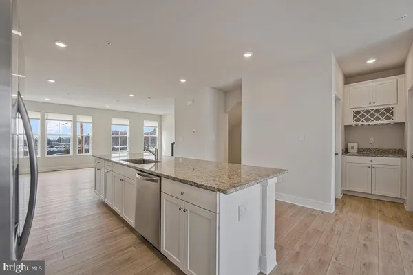 a large kitchen with stainless steel appliances granite countertop a lot of counter space and wooden floors