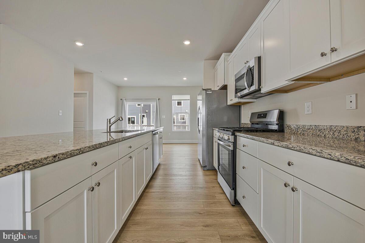 7268 Contee Road Laurel, MD 20707 - Photo 21 of 42 a large kitchen with stainless steel appliances granite countertop a lot of counter space and a sink