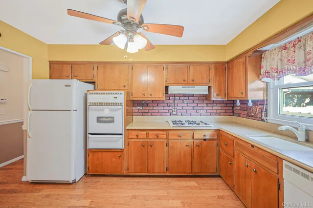 a kitchen with a refrigerator a sink and dishwasher with wooden floor