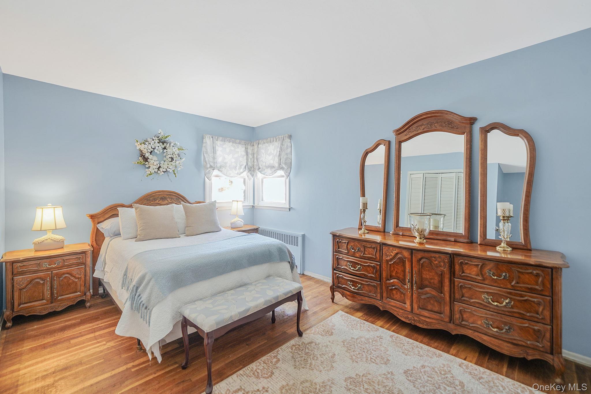 2009 Newbridge Road Bellmore, NY 11710 - Photo 15 of 24 a bedroom with a bed and wooden floor