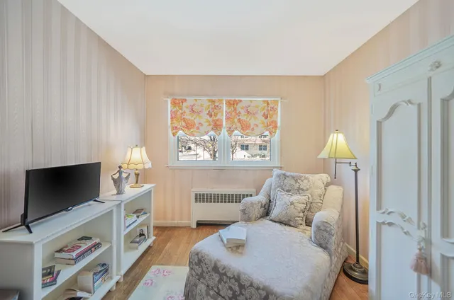 a bedroom with a bed and a flat tv screen on the dresser