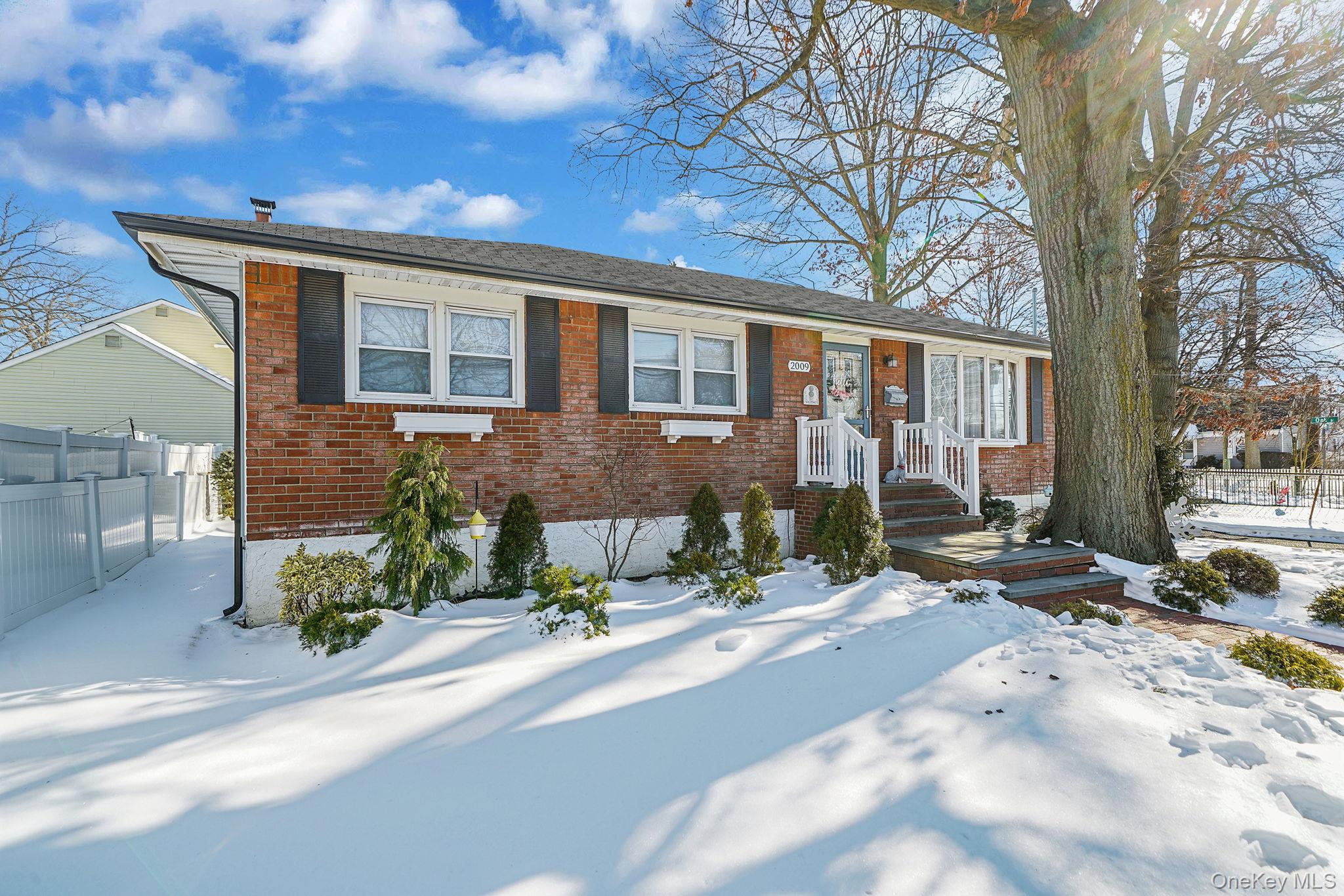 2009 Newbridge Road Bellmore, NY 11710 - Photo 2 of 24 a front view of a house with a yard