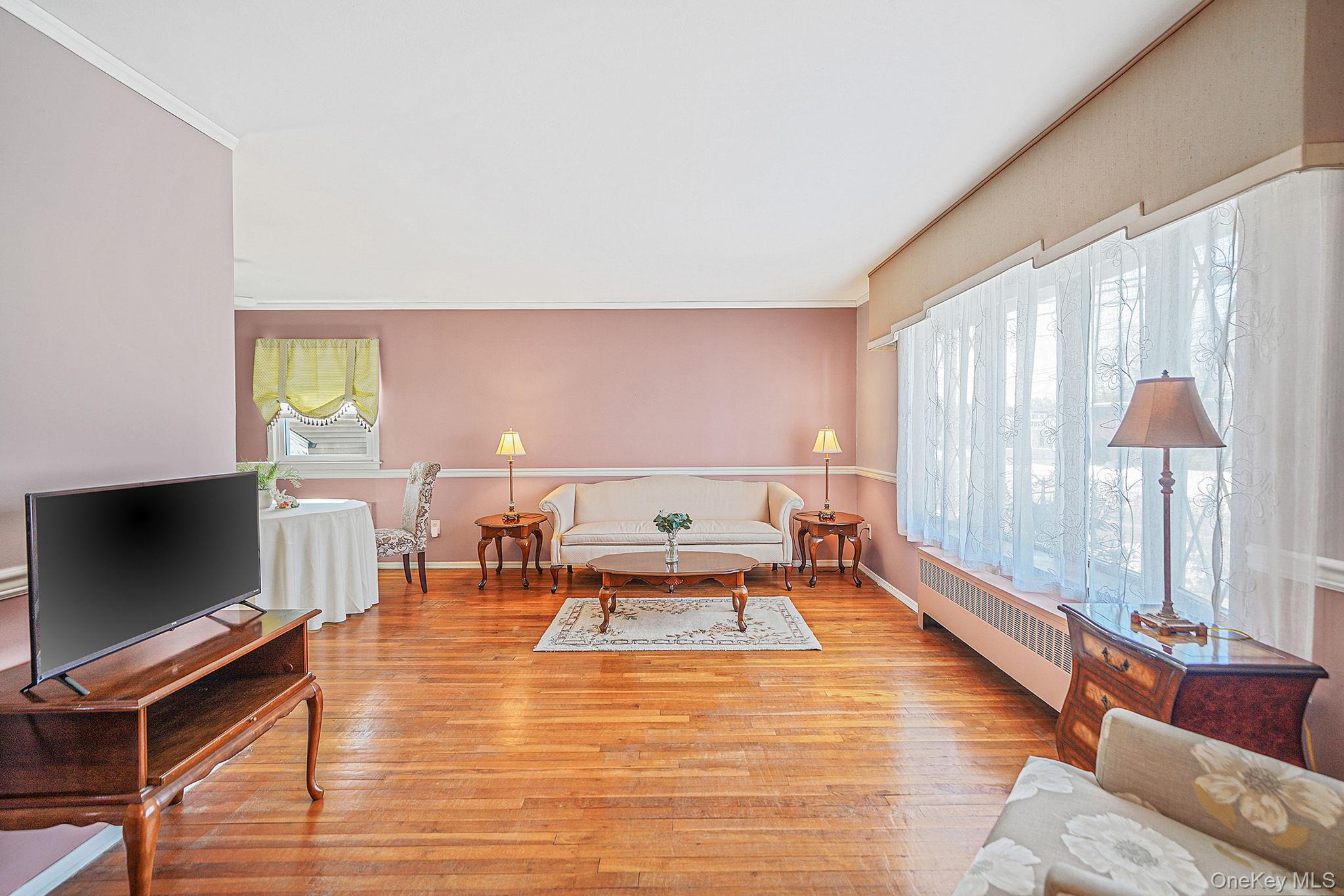 2009 Newbridge Road Bellmore, NY 11710 - Photo 8 of 24 a living room with furniture and a flat screen tv