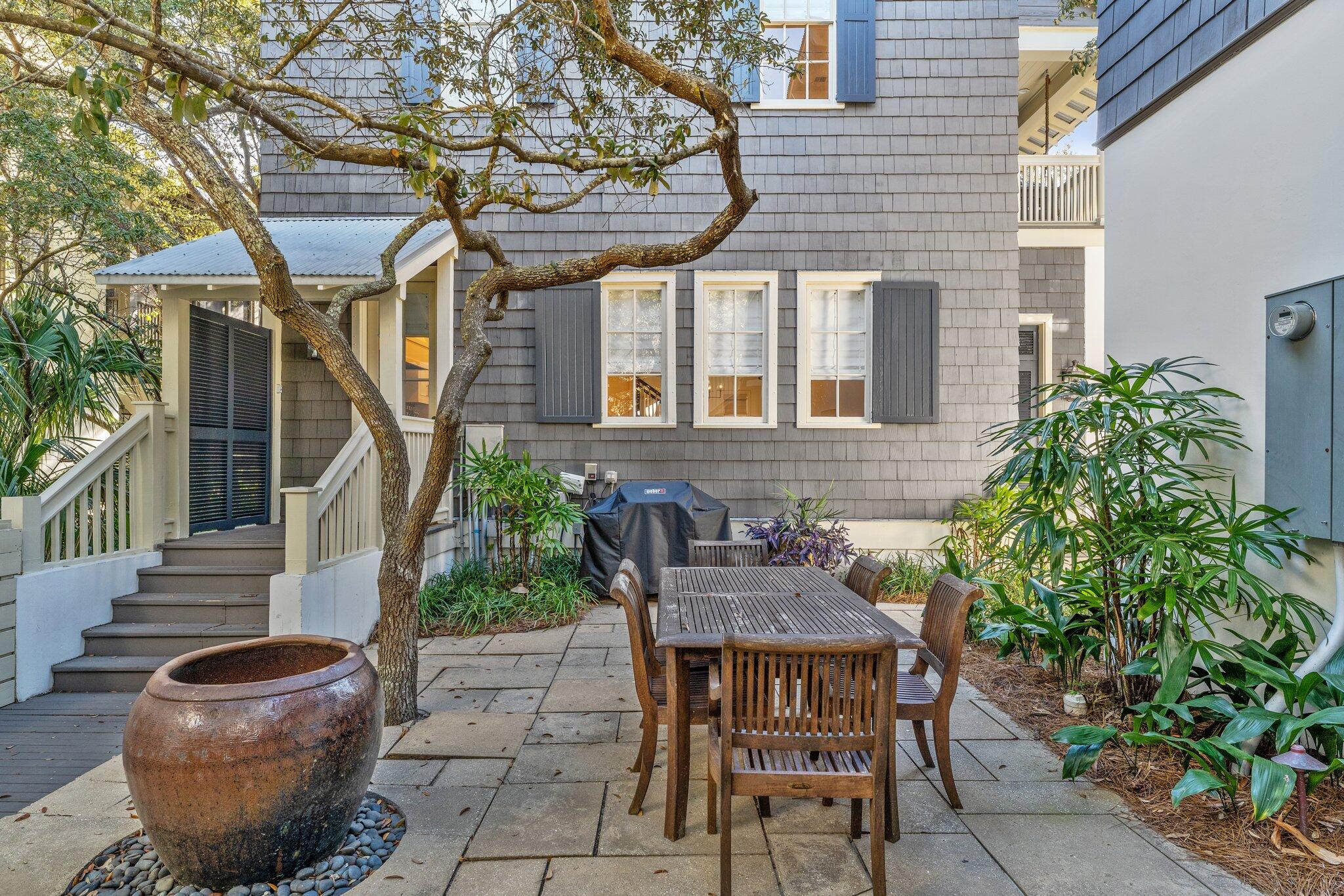 101 Round Road Rosemary Beach, FL 32461 - Photo 44 of 46 a backyard of a house with table and chairs plants
