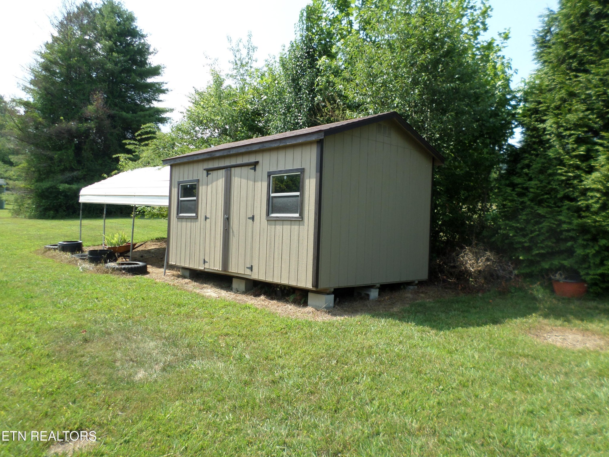 236 Woods Road Oliver Springs, TN 37840 - Photo 20 of 23 a backyard of a house with table and chairs under an umbrella