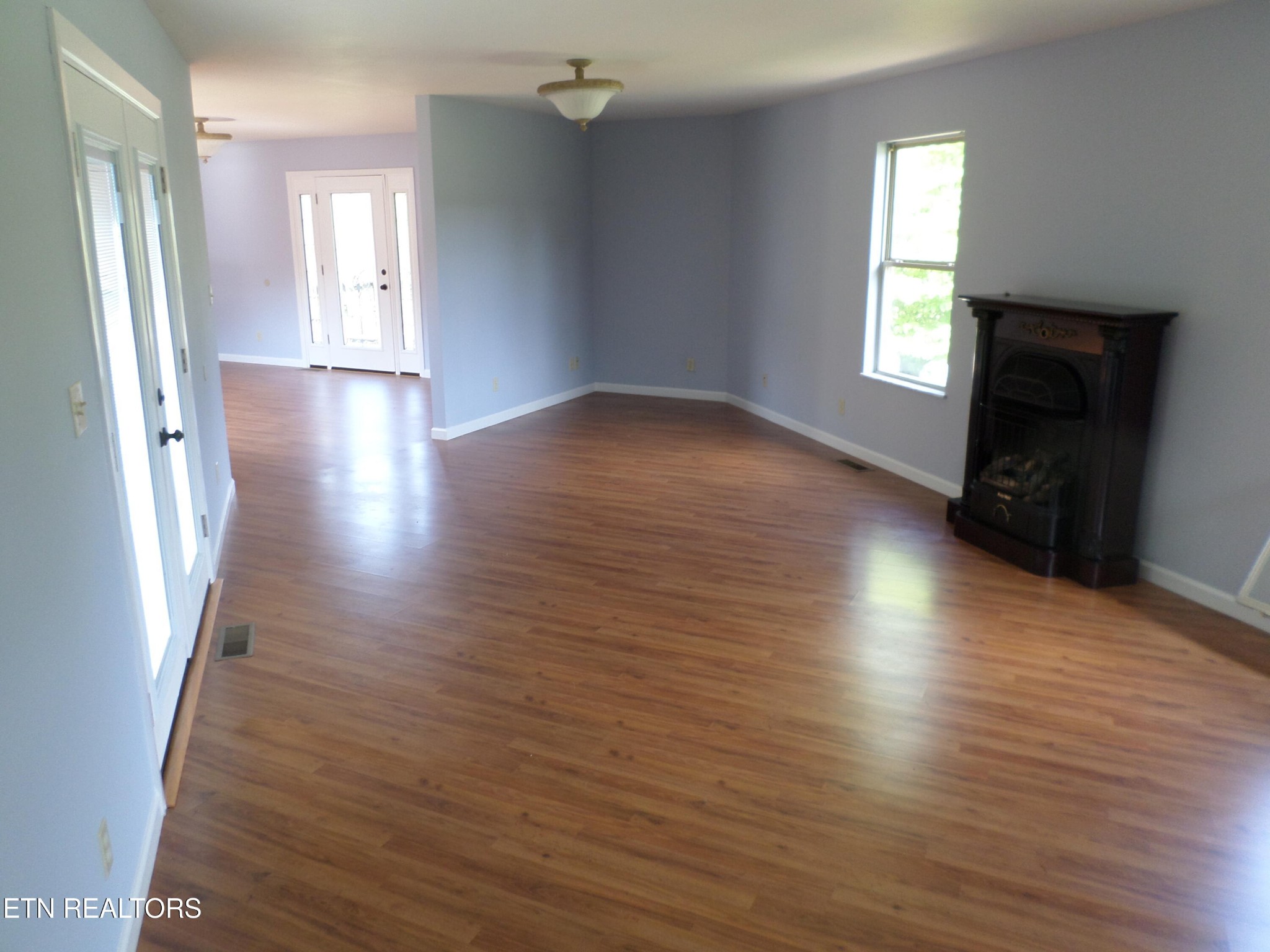236 Woods Road Oliver Springs, TN 37840 - Photo 3 of 23 an empty room with wooden floor and windows