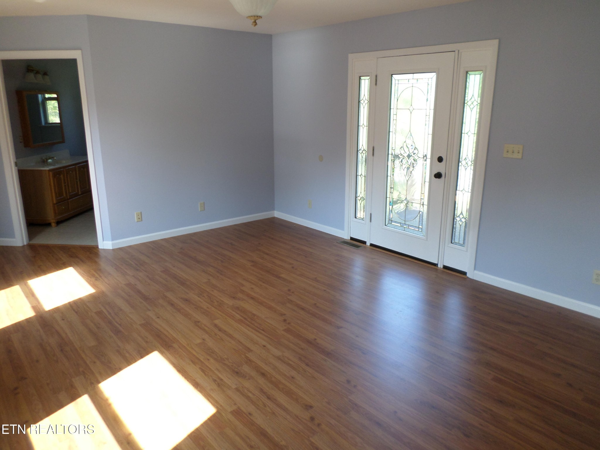 236 Woods Road Oliver Springs, TN 37840 - Photo 4 of 23 an empty room with wooden floor and windows