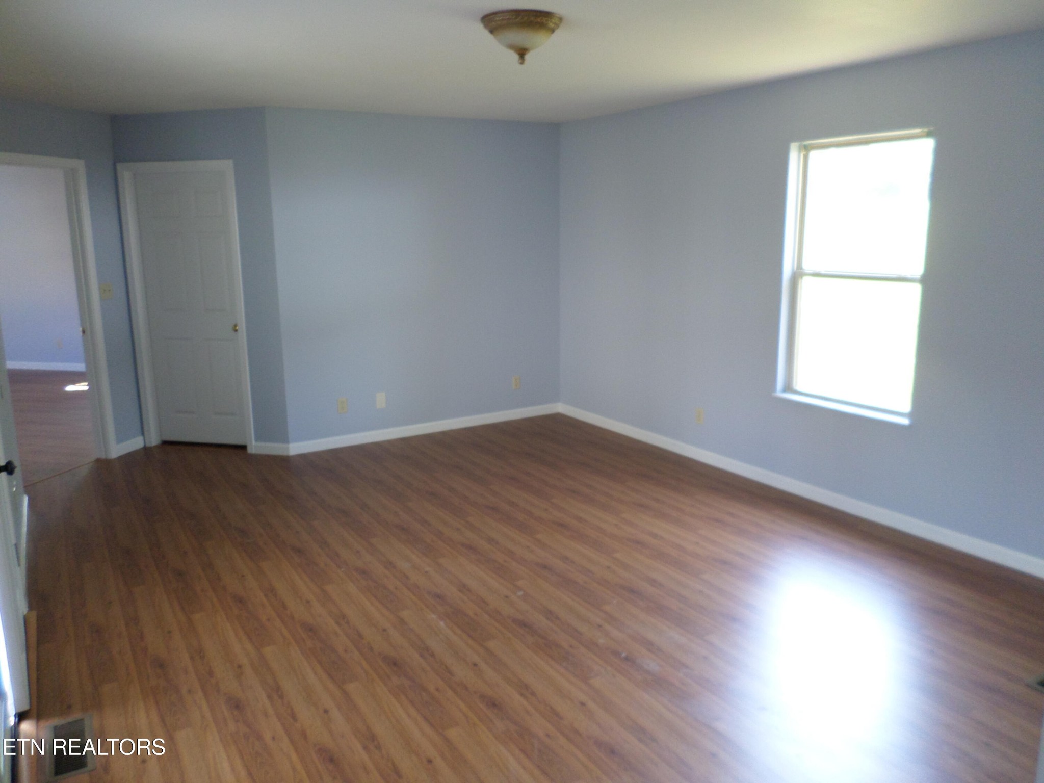 236 Woods Road Oliver Springs, TN 37840 - Photo 6 of 23 an empty room with wooden floor and windows