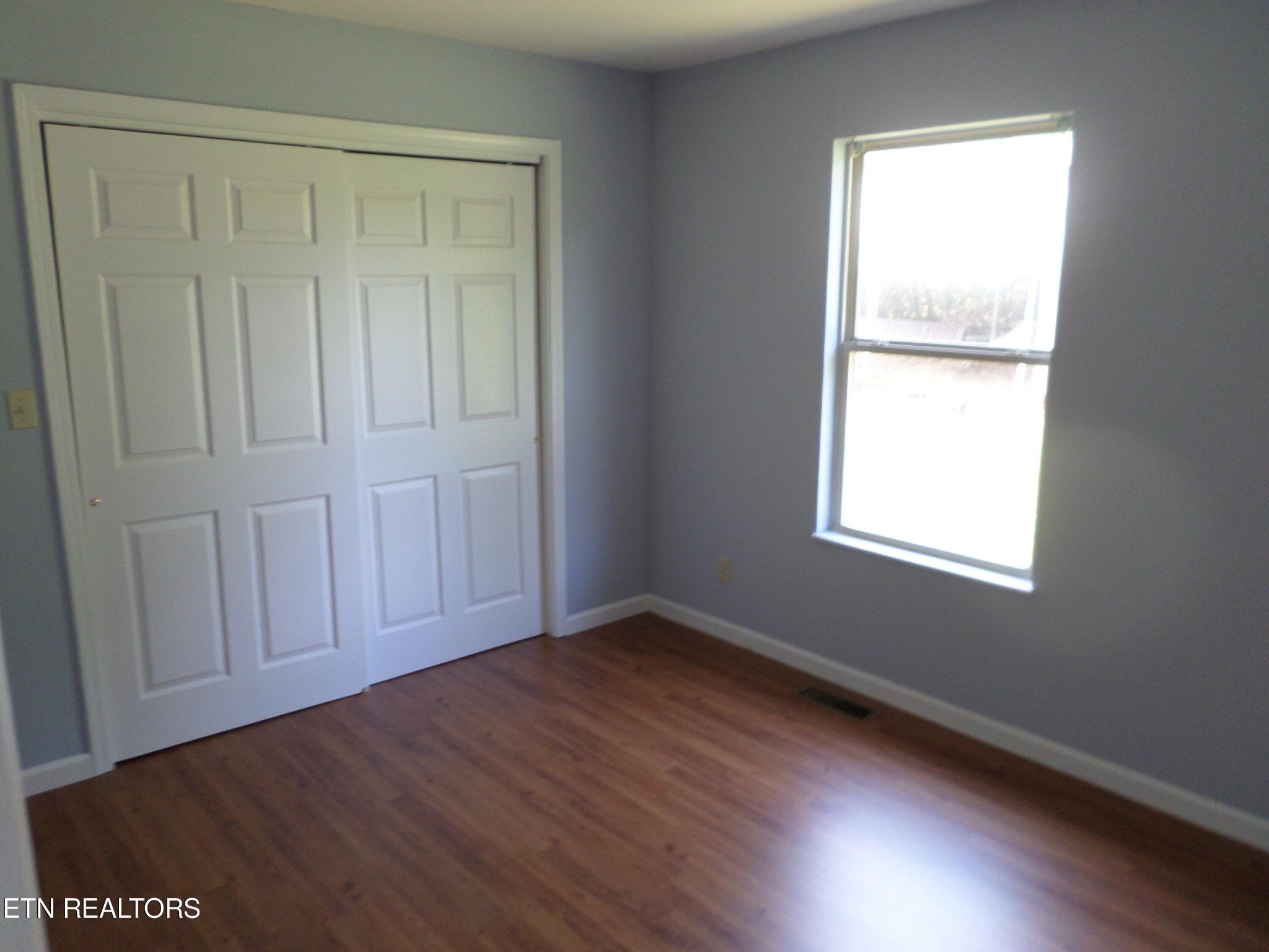 236 Woods Road Oliver Springs, TN 37840 - Photo 10 of 23 an empty room with wooden floor and windows