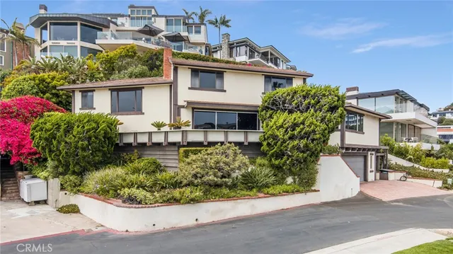 a front view of a house with a yard and potted plants