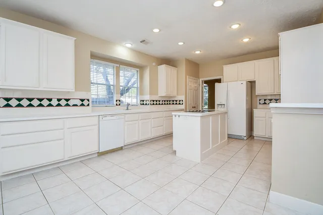 a kitchen with white cabinets and white appliances