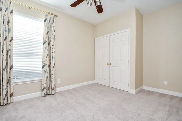 an empty room with chandelier fan