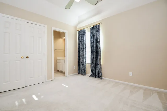 an empty room with a ceiling fan and a window
