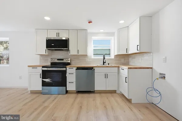 a kitchen with a sink a microwave and cabinets