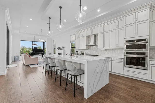 a large kitchen with lots of counter space a sink appliances and a dining table