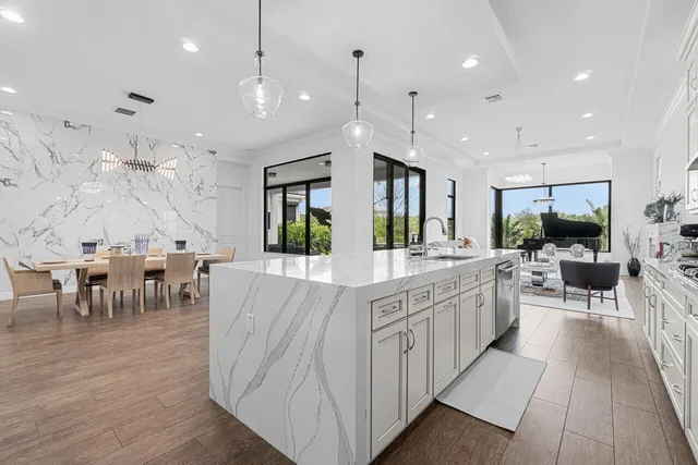 a large white kitchen with lots of counter space wooden floor and appliances