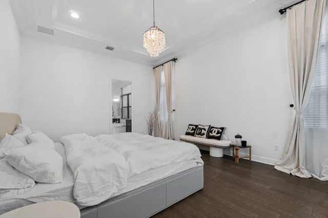 a spacious bedroom with a bed and a chandelier