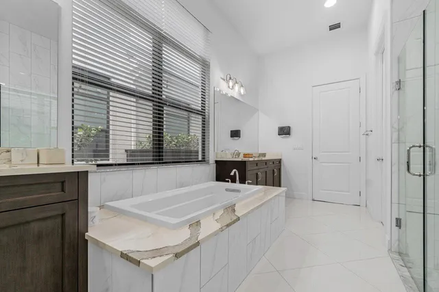 a spacious bathroom with a granite countertop double sink and a mirror