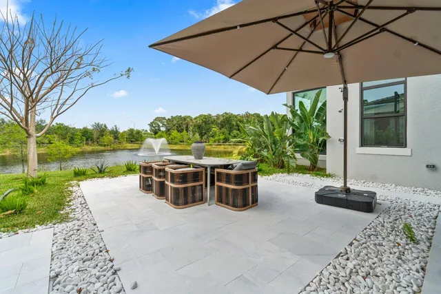 a view of a patio with couches table and chairs under an umbrella