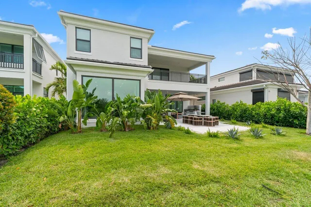 a view of a patio with table and chairs potted plants and a large tree