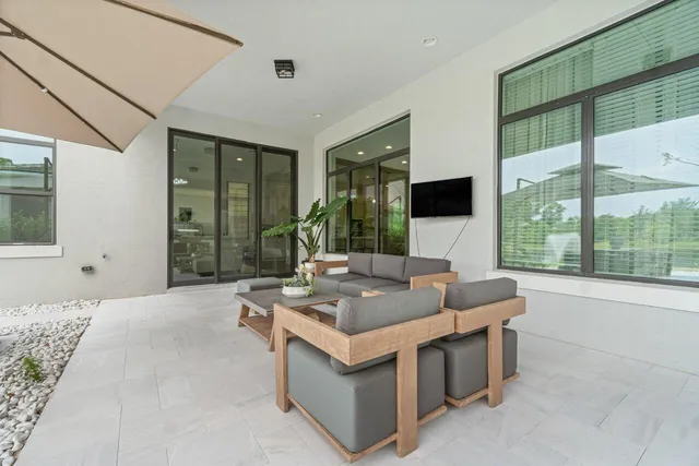 a view of a patio with a table and chairs under an umbrella
