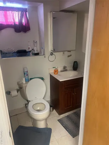 a bathroom with a toilet a sink and mirror
