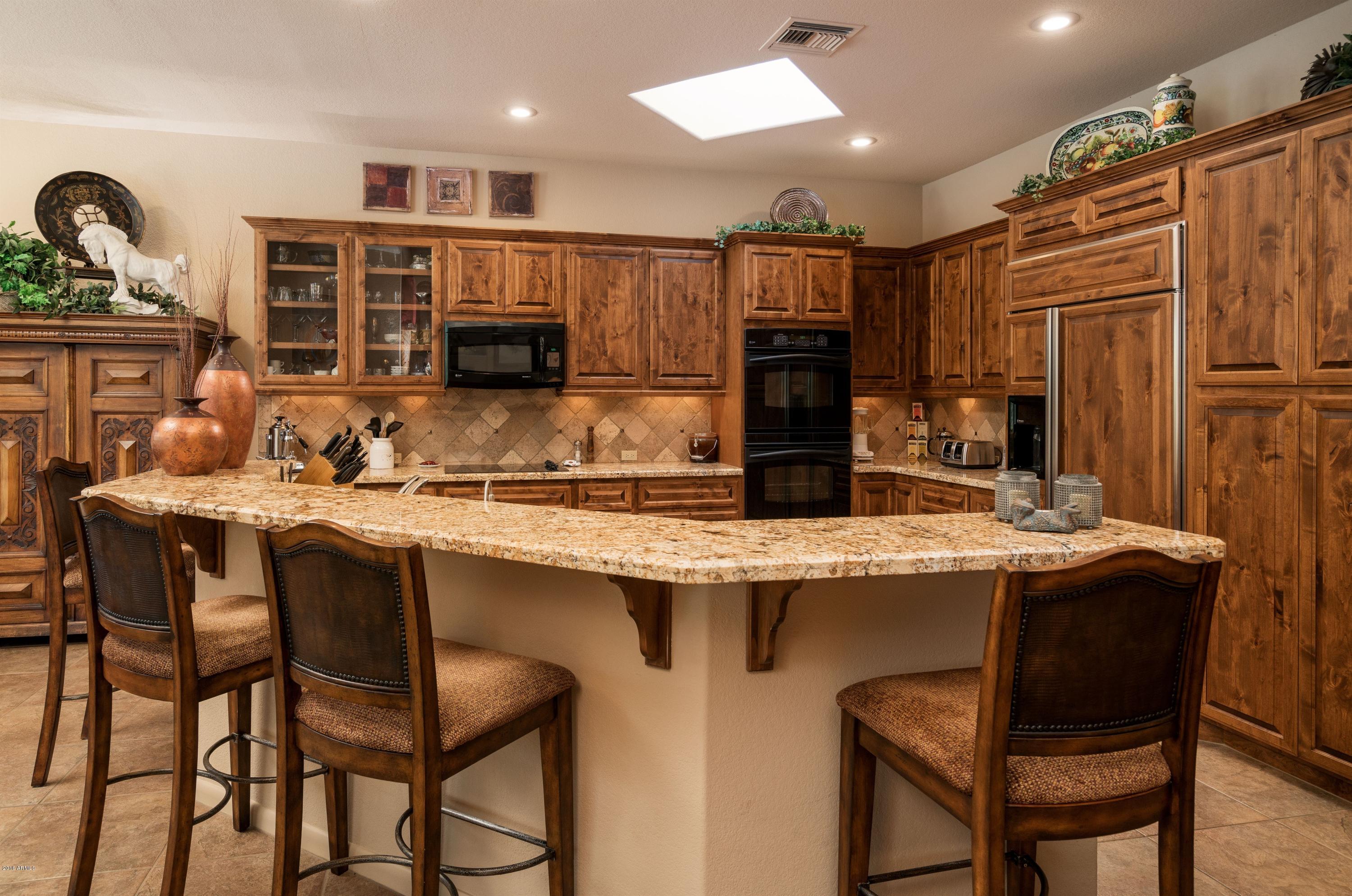 27913 North Quail Spring Road Rio Verde, AZ 85263 - Photo 11 of 63 a kitchen with kitchen island granite countertop a table and chairs in it