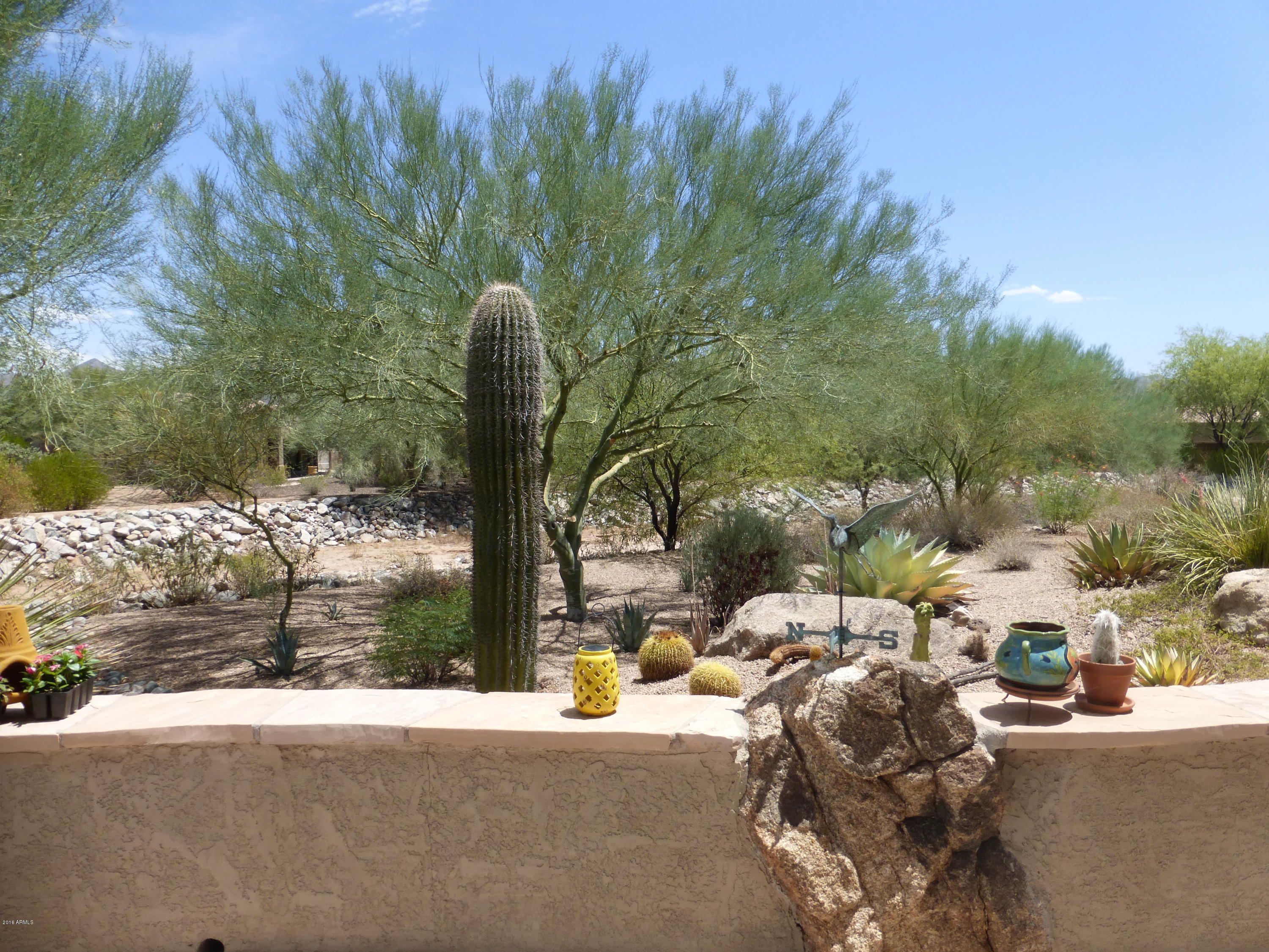 27913 North Quail Spring Road Rio Verde, AZ 85263 - Photo 31 of 63 a picture of a yard with table and chairs and potted plants