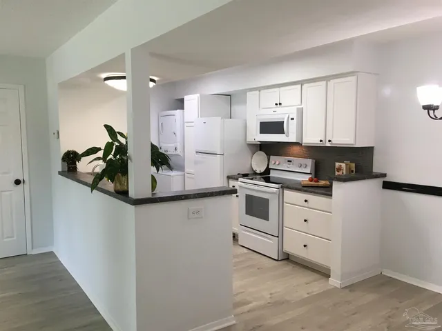 a kitchen with white cabinets and stainless steel appliances