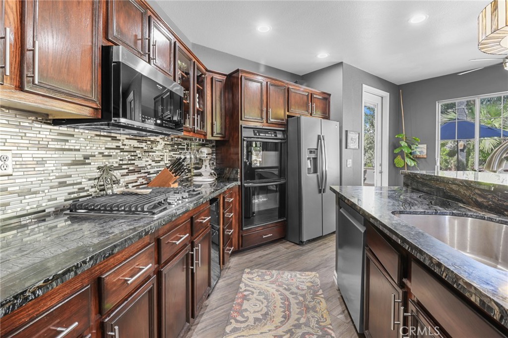 12786 North Rim Way Rancho Cucamonga, CA 91739 - Photo 17 of 50 a kitchen with stainless steel appliances granite countertop a sink stove and refrigerator
