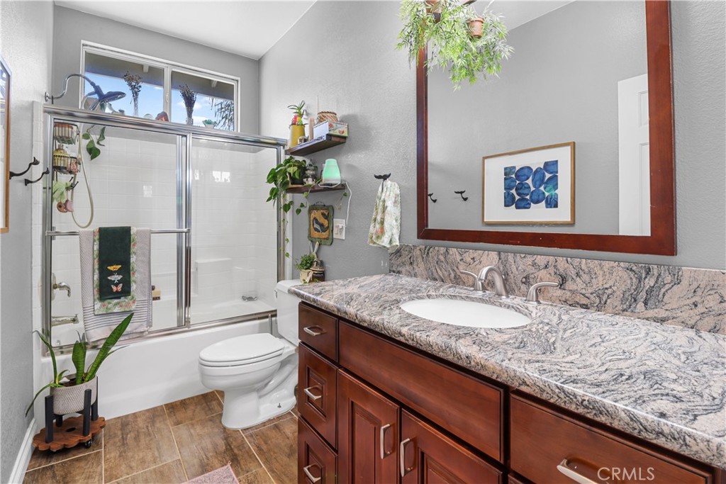 12786 North Rim Way Rancho Cucamonga, CA 91739 - Photo 36 of 50 a bathroom with a granite countertop sink a toilet and a shower