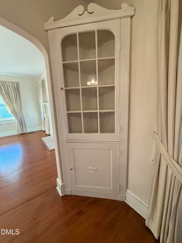 a view of empty room with wooden floor and entryway