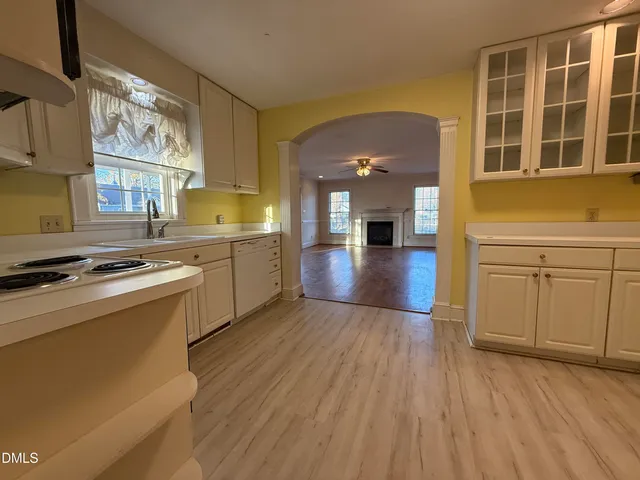 a kitchen with a sink and wooden floor