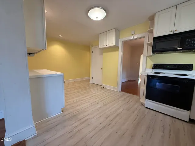 a kitchen with stainless steel appliances a stove a microwave and a hard wood floors