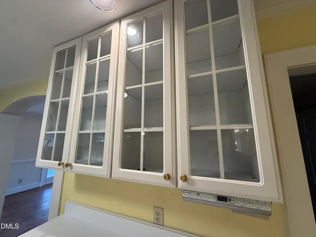 a view of an empty room with wooden floor and windows