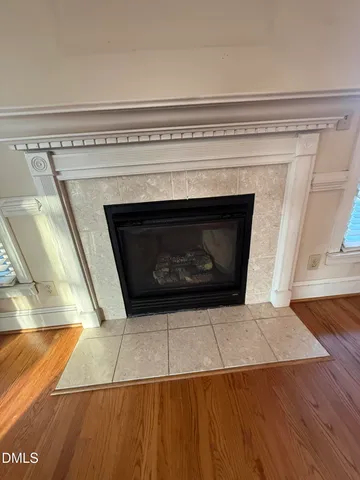 a living room with a fireplace and wooden floor