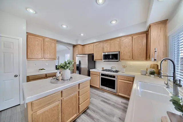 a kitchen with stainless steel appliances granite countertop a sink stove and refrigerator