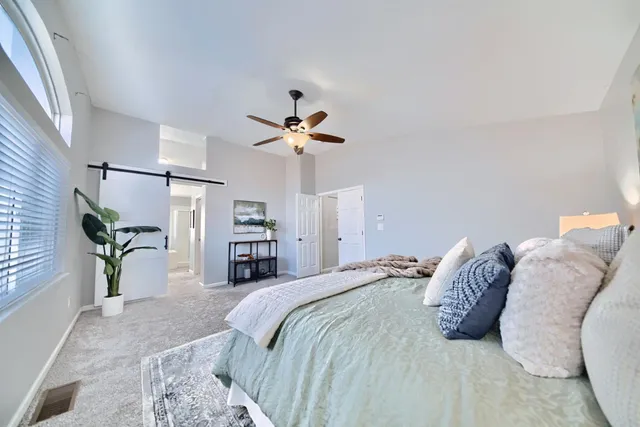 a bedroom with a large bed and a chandelier