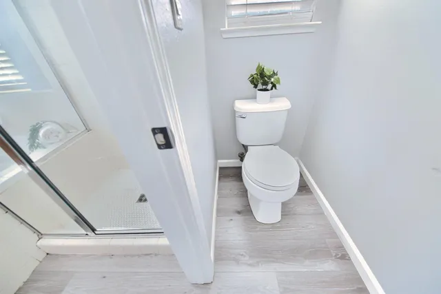 a white toilet sitting next to a white tub and a shower