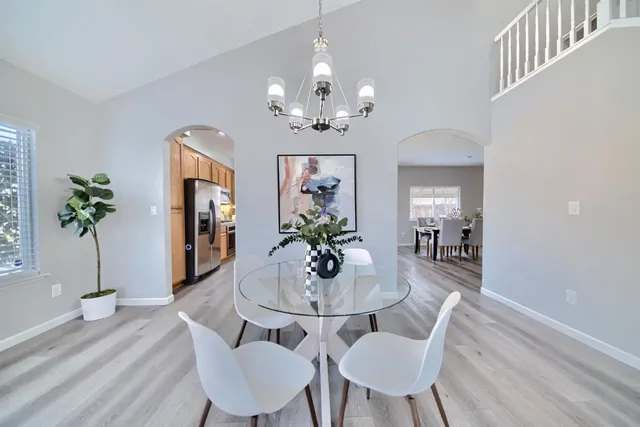 a dining room with furniture potted plants and wooden floor