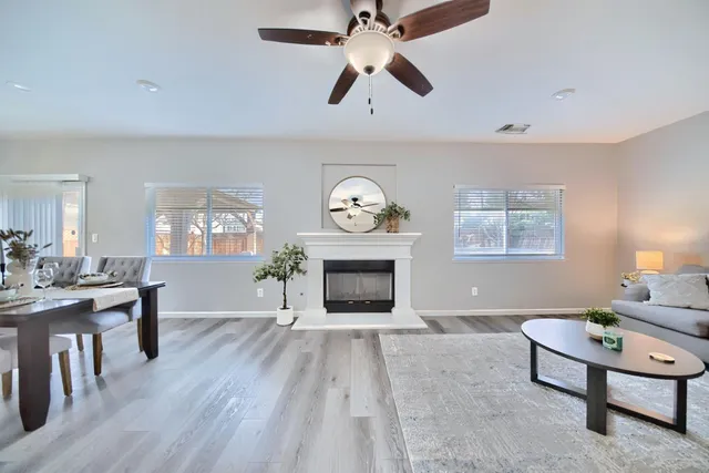 a living room with furniture a fireplace and a large window