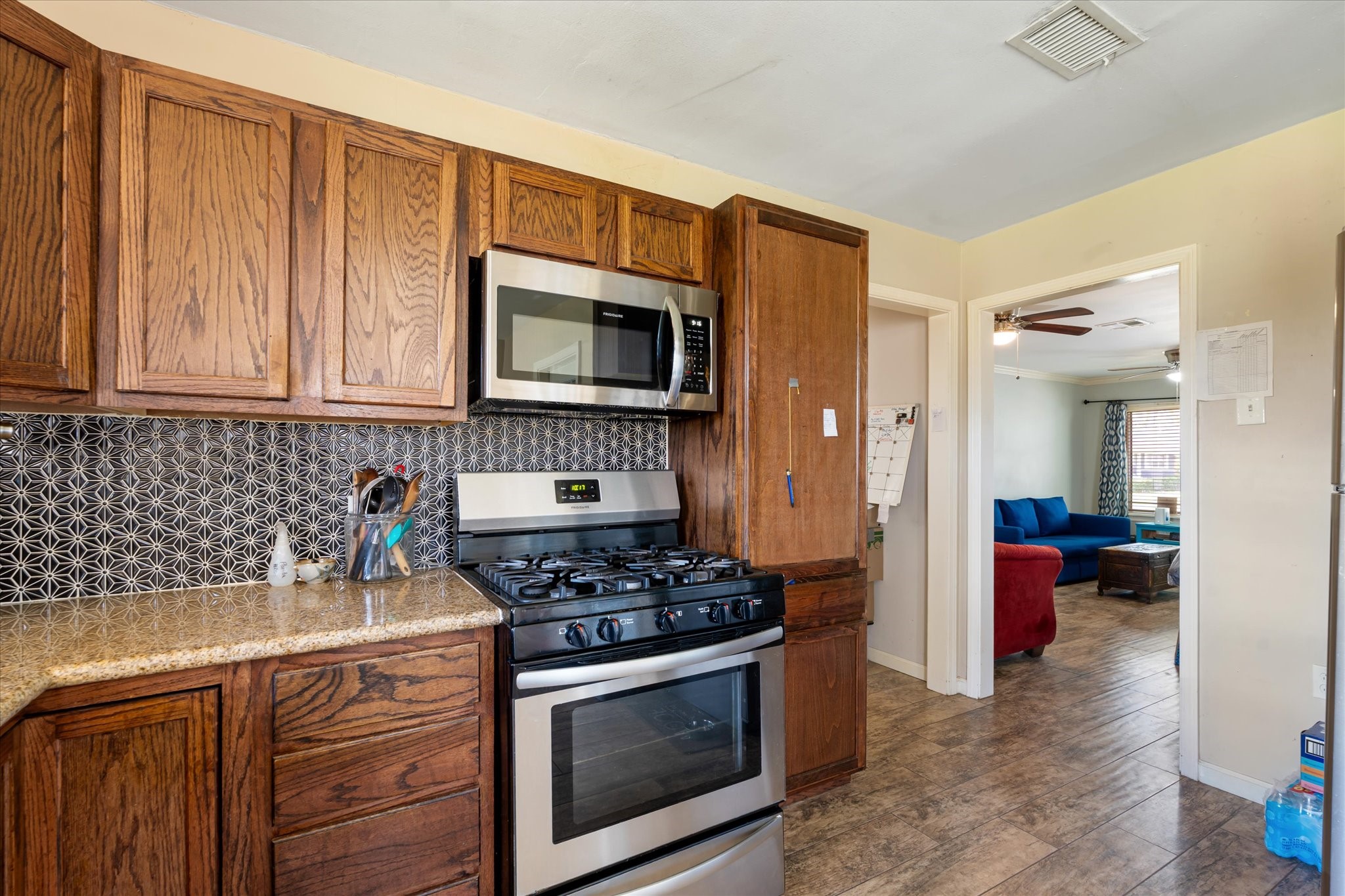 2423 Metz Street Houston, TX 77034 - Photo 12 of 22 a kitchen with stainless steel appliances a stove a microwave and cabinets