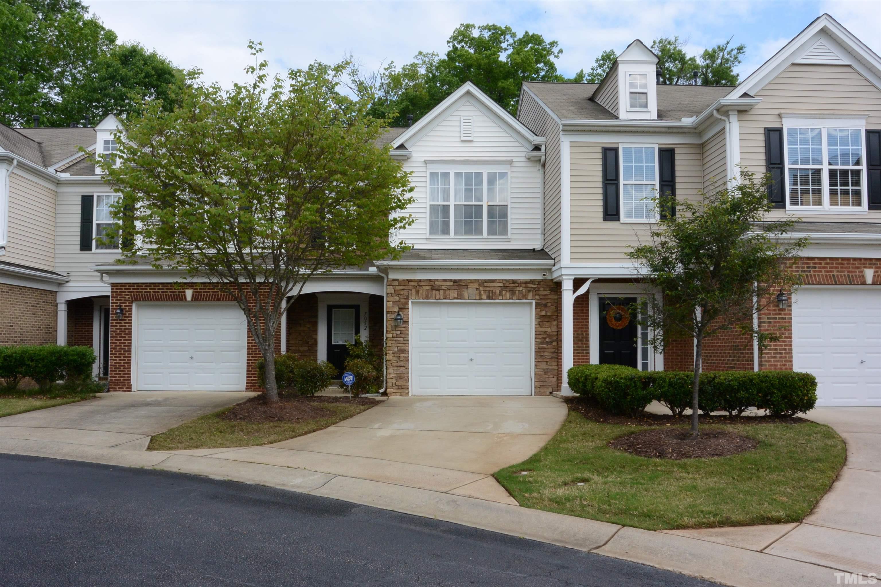 7052 Racine Way, Unit N/A Raleigh, NC 27615 - Photo 1 of 11 a front view of a house with a yard and garage