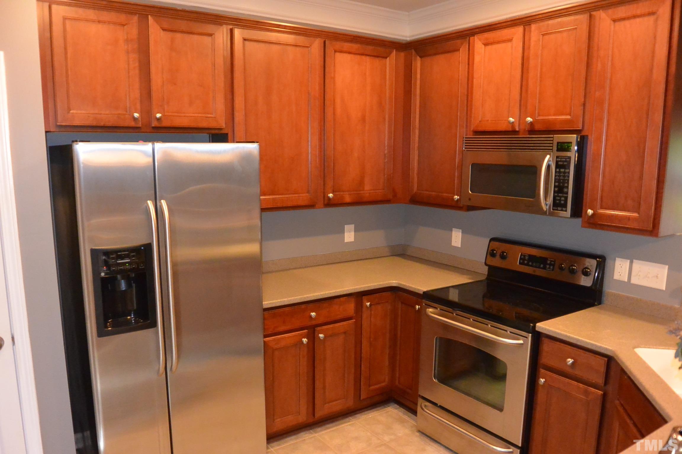 7052 Racine Way, Unit N/A Raleigh, NC 27615 - Photo 2 of 11 a kitchen with a refrigerator stove and microwave