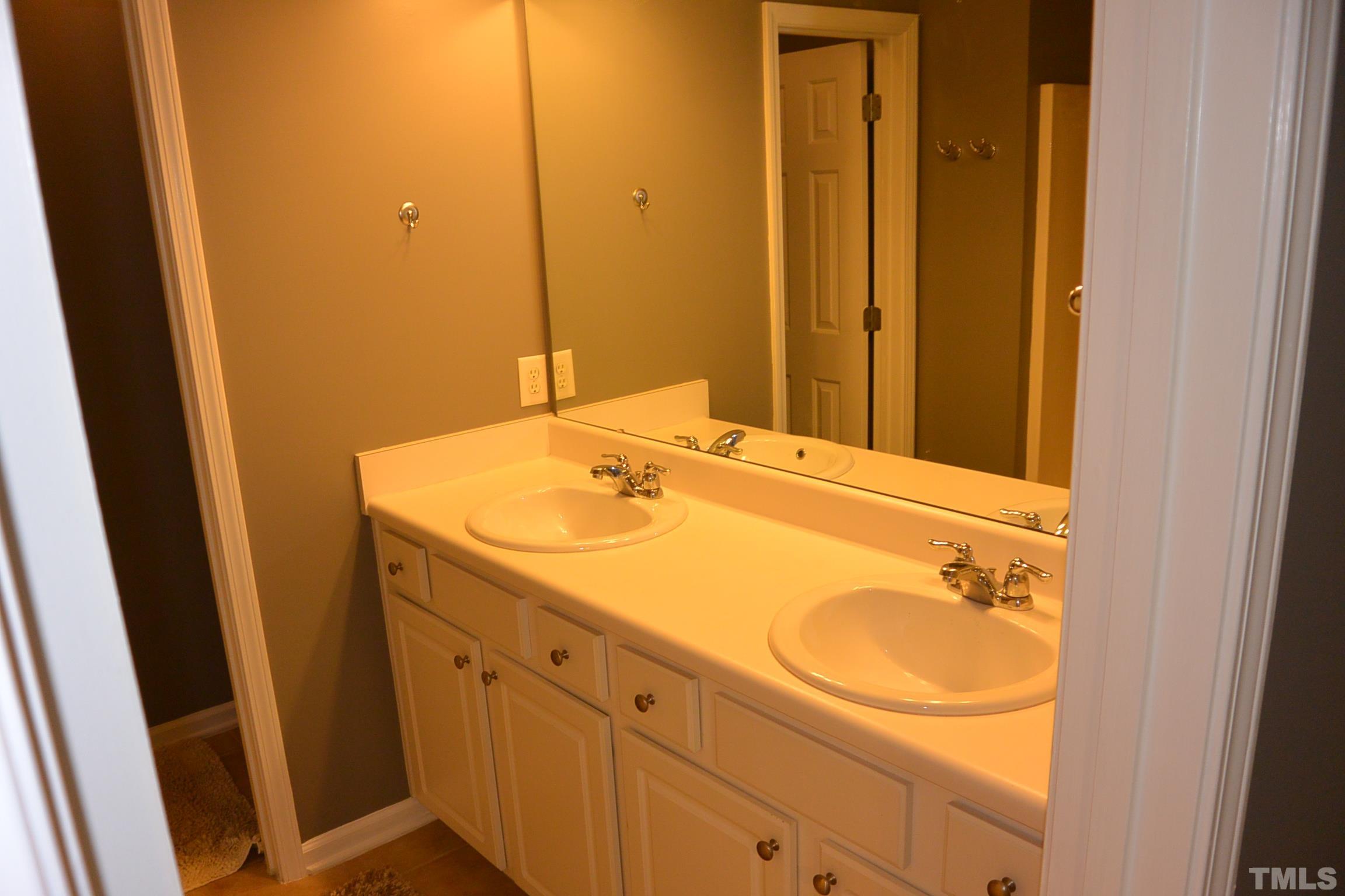 7052 Racine Way, Unit N/A Raleigh, NC 27615 - Photo 9 of 11 a bathroom with a sink and a mirror