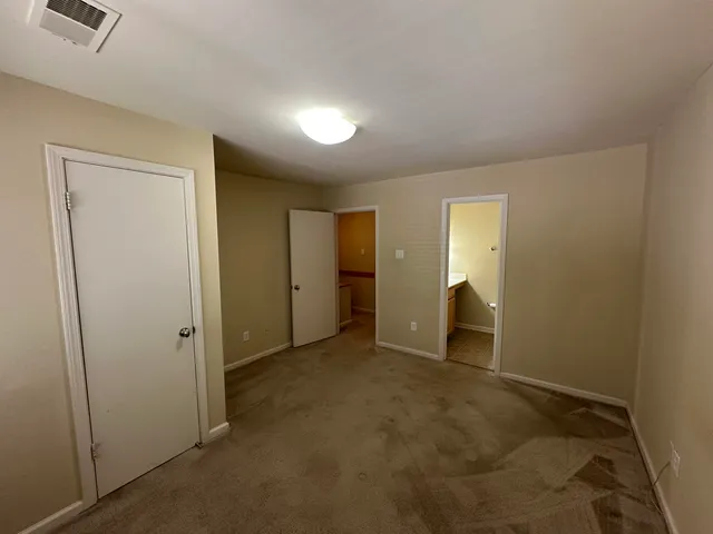 an empty room with closet and bathroom