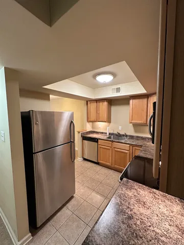 a kitchen with stainless steel appliances granite countertop a refrigerator sink and stove